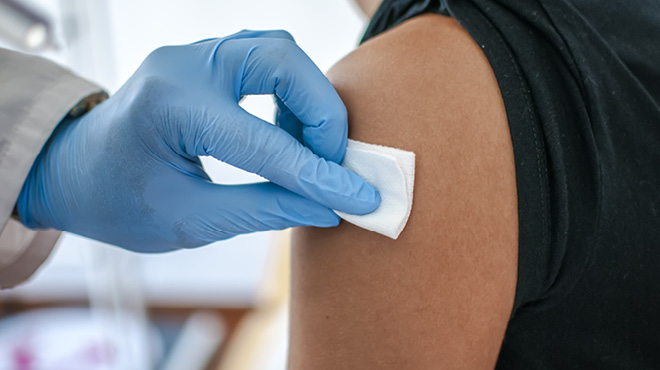 带手套的手把垫在注射后的手臂