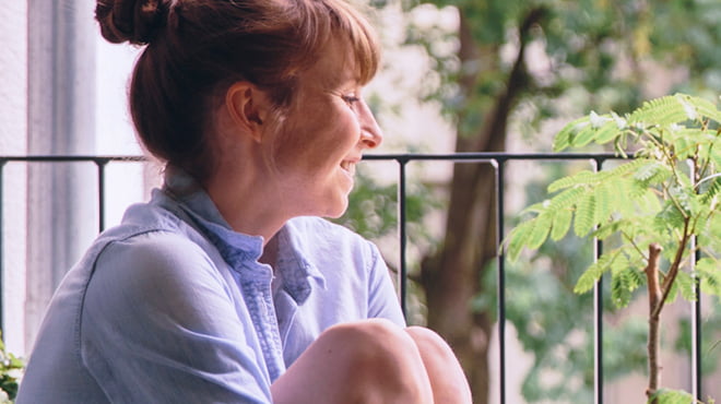 坐着,拥抱弯曲的膝盖关闭